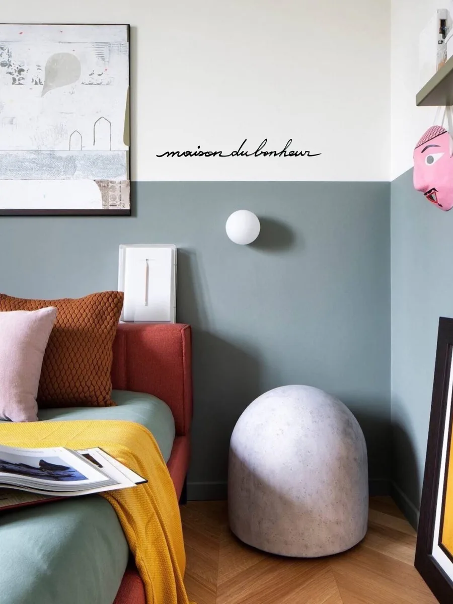 La phrase Maison du bonheur en noir, collée au mur d'un salon