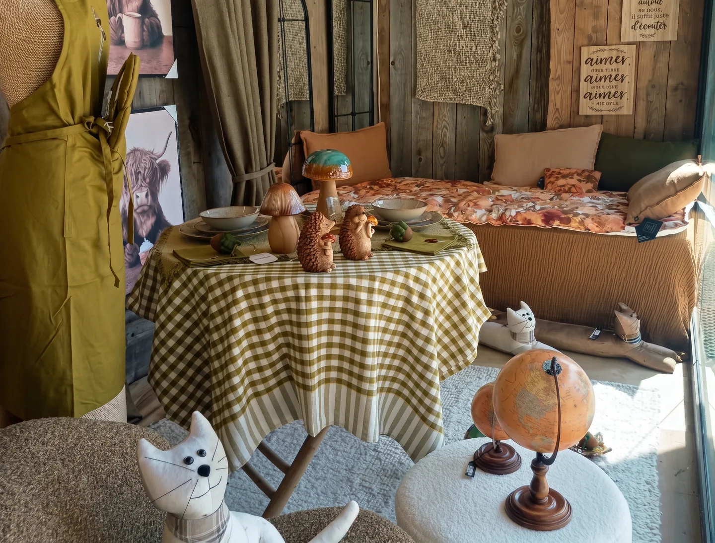 Vue d'ensemble de la vitrine, fauteuil, table dressée, mannequin et panneaux muraux