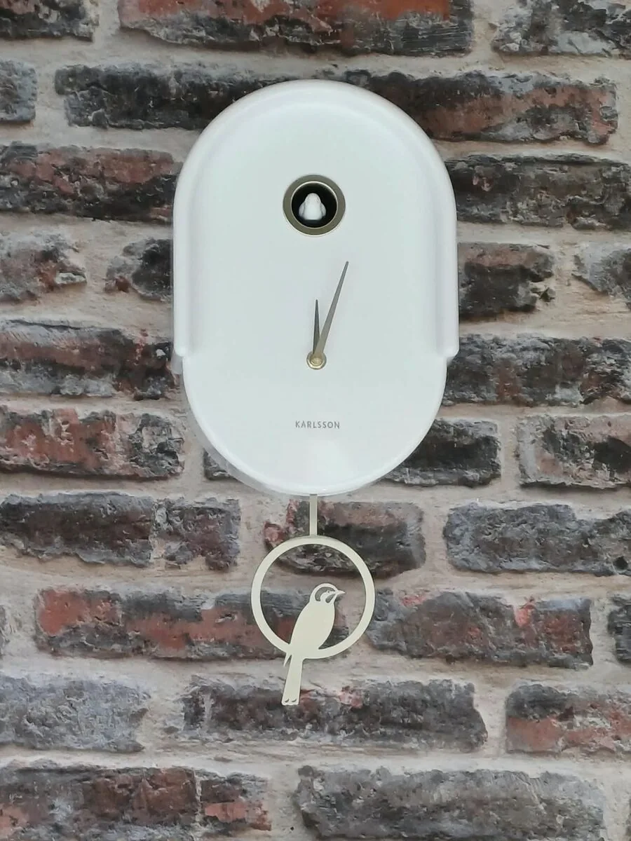 Une horloge Tweet blanche sur le mur de briques de la boutique